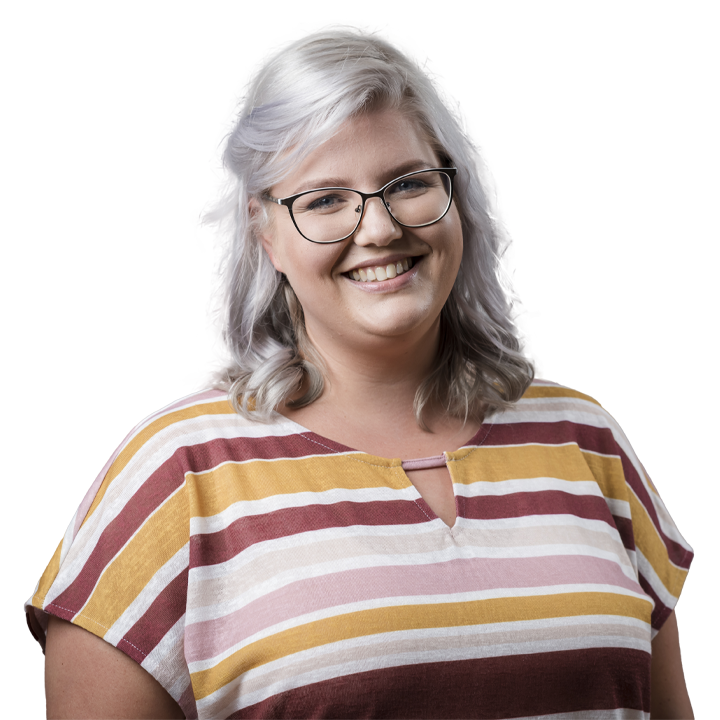 Eine junge Frau mit weißblonden Haaren und Brille lächelt. Sie strahlt Wärme und Offenheit aus. 
